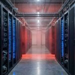 Data center server aisle with one section glowing red, illustrating suspended access to AI models